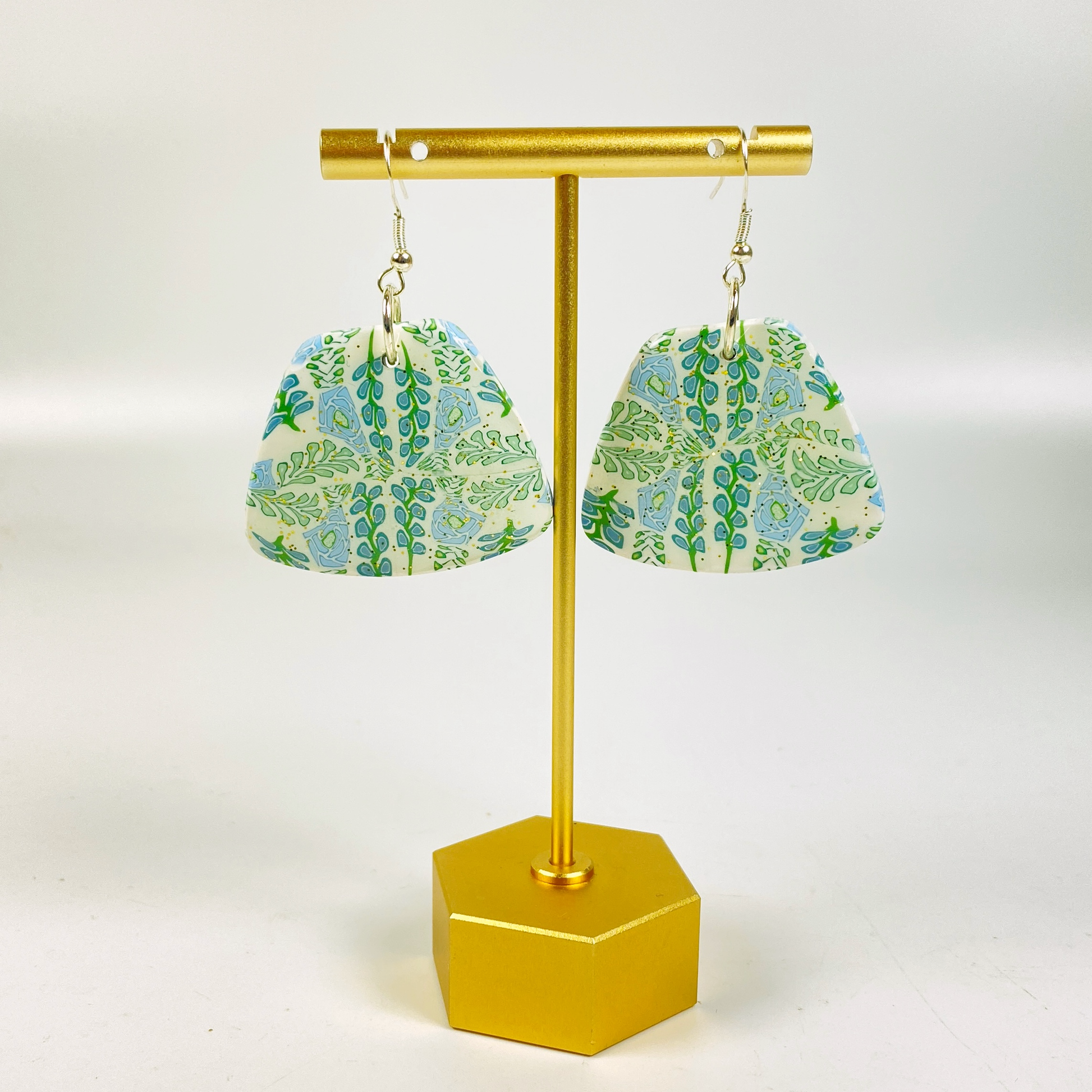 Blue Blossom Handmade Polymer Clay Trapezoid Earrings on a brass earring stand.