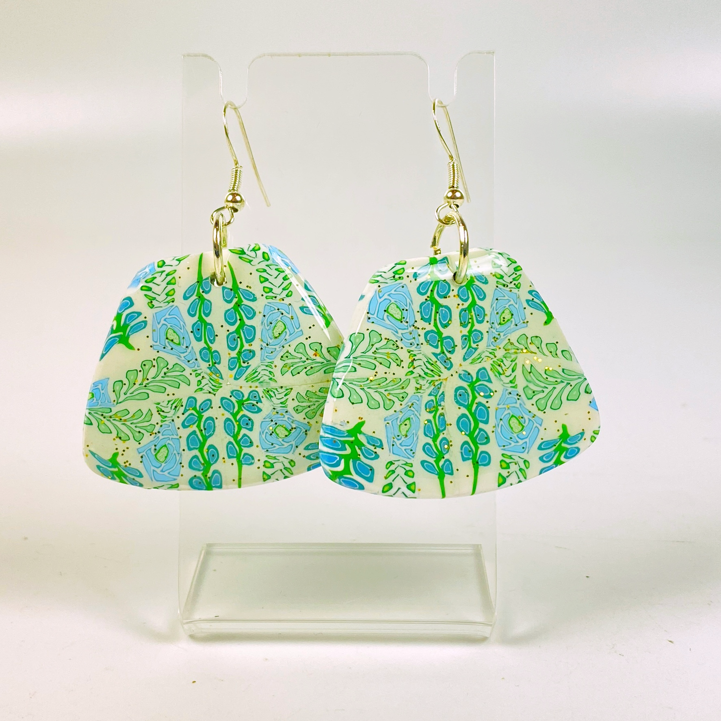 Blue Blossom Handmade Polymer Clay Trapezoid Earrings on a clear acrylic earring stand