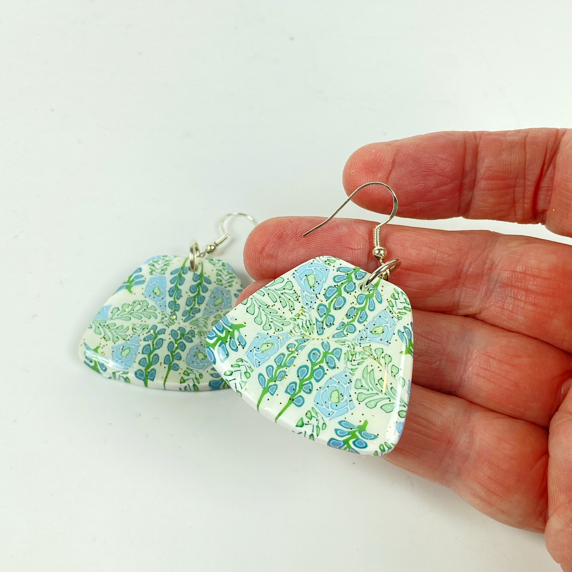 Blue Blossom Handmade Polymer Clay Trapezoid Earrings handheld for size reference
